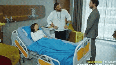 Woman In Hospital Bed Surrounded By Men GIF