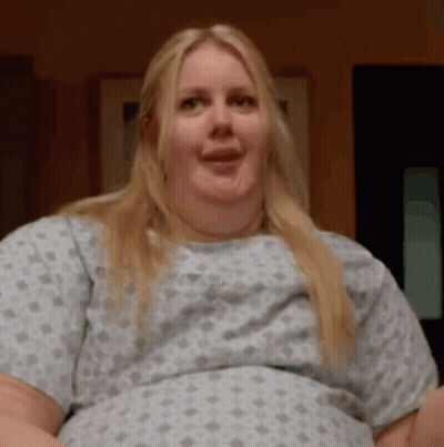 Woman In Hospital Gown Making Funny Face And Smiling GIF