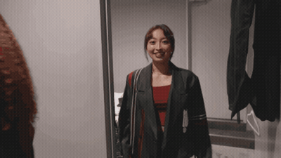 Woman In Jacket Standing Before Mirror GIF