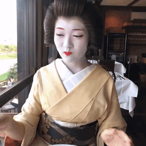 Woman In Kimono With White Paint Looking Out Window GIF