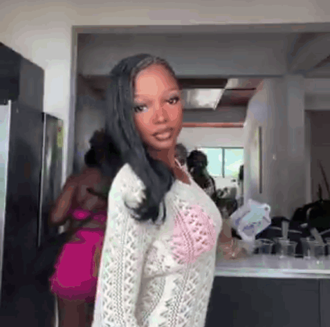Woman In Kitchen Wearing White Sweater And Pink Bra GIF