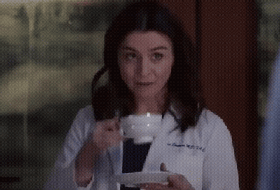 Woman In Lab Coat Holding Coffee Cup And Saucer GIF