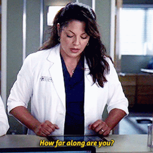 Woman In Lab Coat Looking At Tablet Saying How Far Along Are You GIF