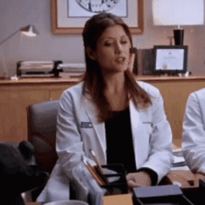 Woman In Lab Coat Sitting At Desk GIF