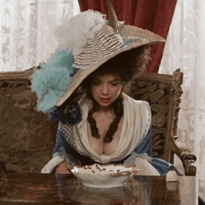 Woman In Large Hat Sitting At Table With Bowl Of Food GIF