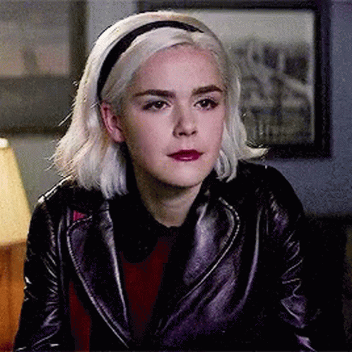 Woman In Leather Jacket And Headband Sitting In Room GIF