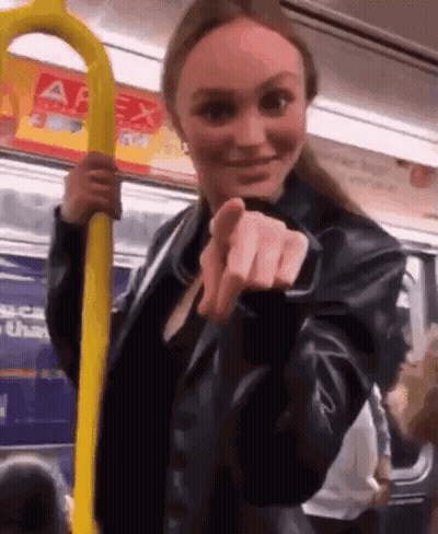 Woman In Leather Jacket Holding Yellow Railing On Bus GIF