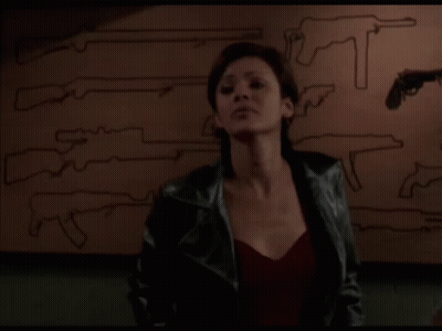 Woman In Leather Jacket In Front Of Guns Saying Yeah Right GIF