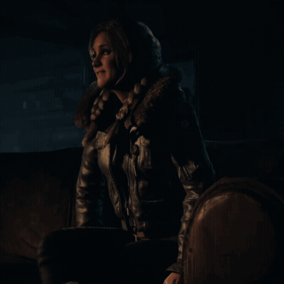 Woman In Leather Jacket Sits On Couch In Dark Room GIF