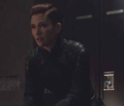 Woman In Leather Jacket Sitting By Locker GIF