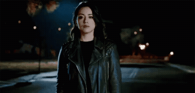 Woman In Leather Jacket Standing In Dark Street GIF