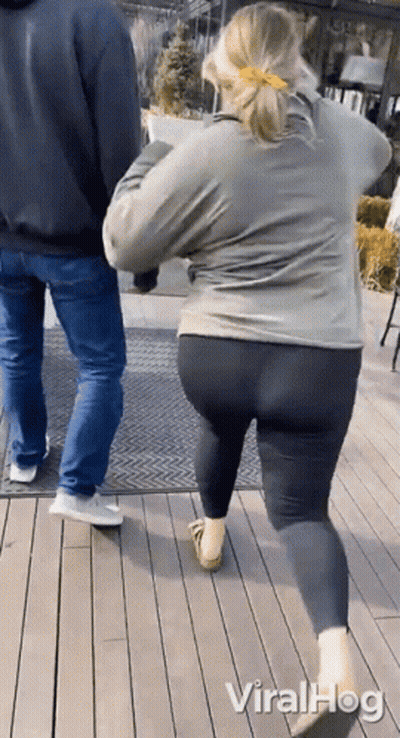 Woman In Leggings Walking Beside Man In Jeans On Wood Deck GIF