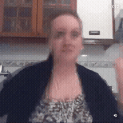Woman In Leopard Print Arms Outstretched In Kitchen GIF