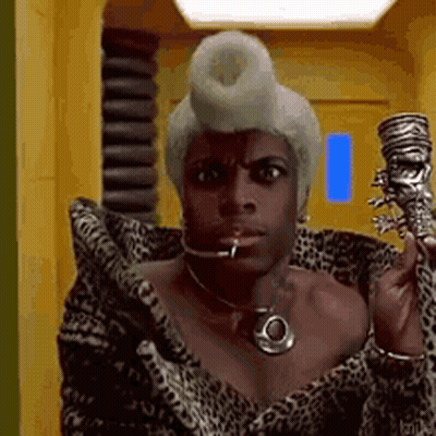 Woman In Leopard Print Coat And Wig Holding Skull GIF