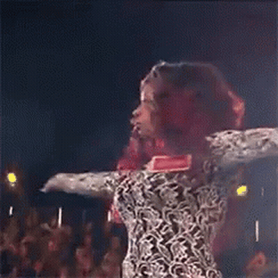 Woman In Leopard Print Dress Dancing With Arms Outstretched GIF