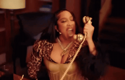 Woman In Leopard Print Top Talking On Phone GIF