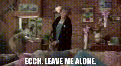 Woman In Living Room Next To Couch Saying Leave Me Alone GIF