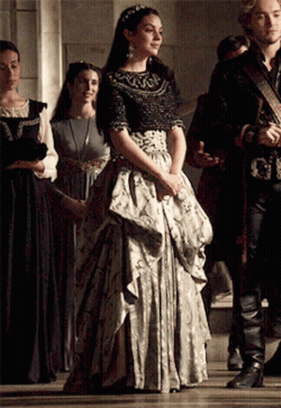 Woman In Long Dress With Group In Hallway GIF