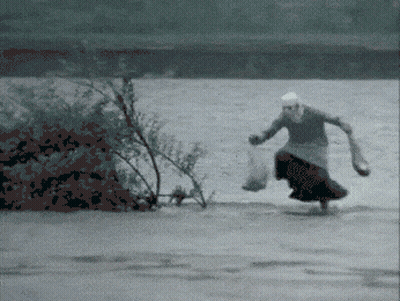 Woman In Long Skirt Running Across River GIF