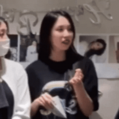 Woman In Mask And Black T-Shirt Next To Woman GIF