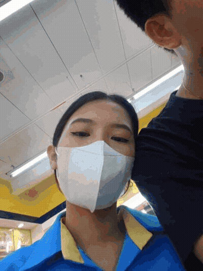 Woman In Mask And Blue Shirt Kissing Man GIF