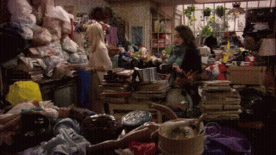 Woman In Messy Room With Pile Of Clothes GIF