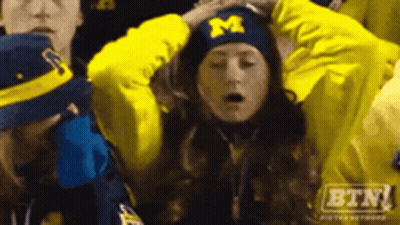 Woman In Michigan Hat Holding Her Head GIF