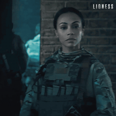 Woman In Military Uniform In Front Of Brick Wall Saying Lioness GIF