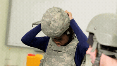Woman in Military Uniform Putting on Bulletproof Vest