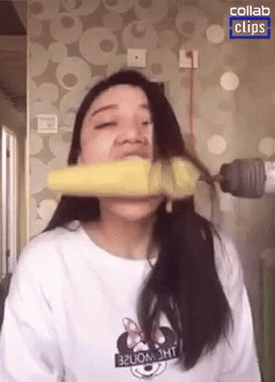 Woman In Minnie Mouse Shirt Biting Banana GIF