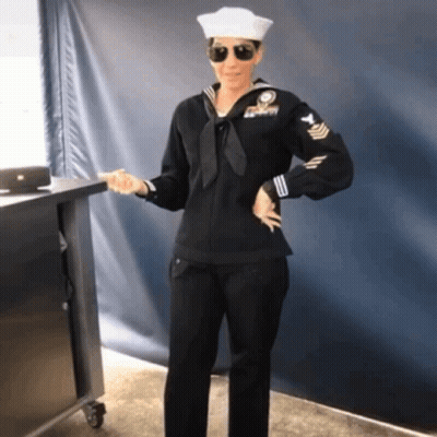 Woman In Navy Uniform In Front Of Blue Wall GIF