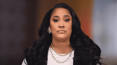Woman In Necklace And Earrings Looking At Camera With Zeus TV Logo GIF