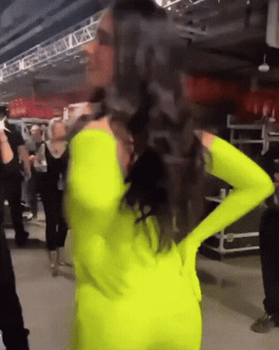 Woman In Neon Yellow Outfit Hands On Hips GIF