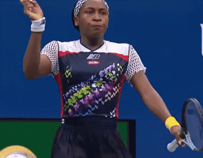 Woman In New Balance Shirt Pointing Up At Usopen.org Sign GIF