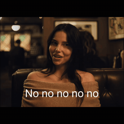 Woman In Off The Shoulder Sweater Smiling In Dark Room GIF