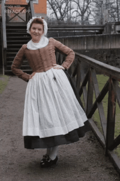 Woman In Old Fashioned Dress Next To Railing GIF