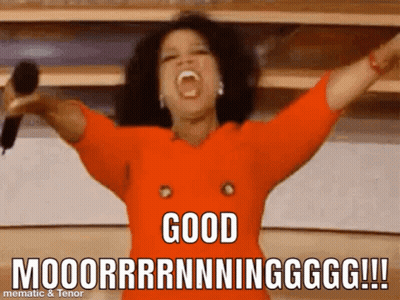 Woman In Orange Shirt Holding Microphone Says Good Moooorrrnnningggg GIF