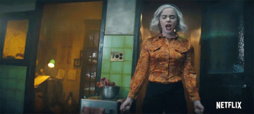 Woman In Orange Shirt In Front Of Netflix Logo GIF