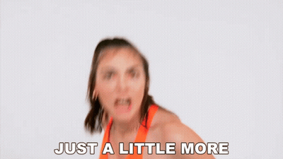 Woman In Orange Top Saying Just A Little More GIF