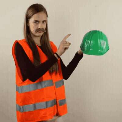 Woman In Orange Vest Pointing At Green Helmet GIF