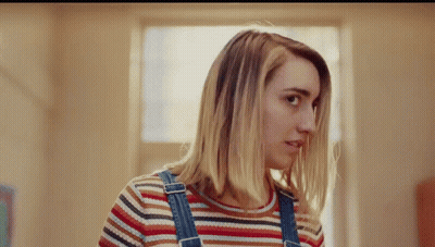 Woman In Overalls And Striped Shirt Looking To Side GIF