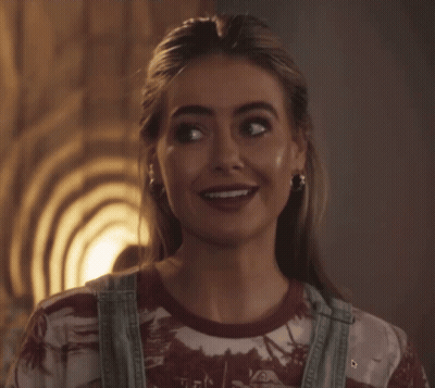 Woman In Overalls And Tie Dye Shirt Smiling GIF