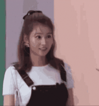 Woman In Overalls And White Shirt Standing GIF