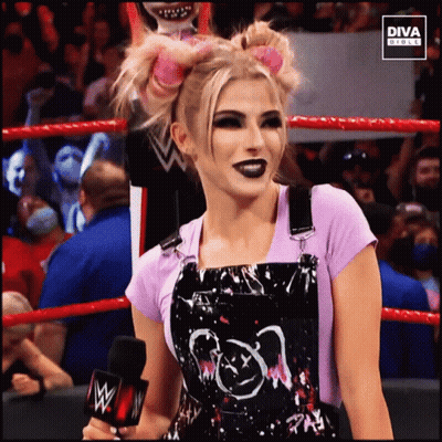 Woman In Overalls In Wrestling Ring With Diva Circle Logo GIF