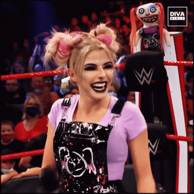 Woman In Overalls In Wrestling Ring With Diva Doll GIF