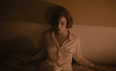 Woman In Pajamas Sitting On Bed GIF