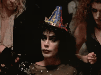 Woman In Party Hat In Dark Room With Others GIF