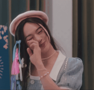 Woman In Pearl Necklace And Pink Hat Wiping Face GIF