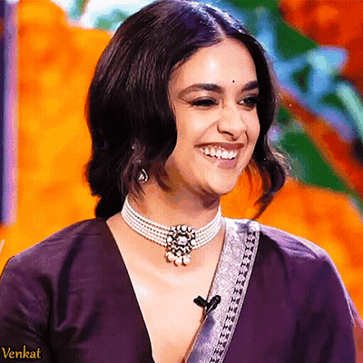 Woman In Pearl Necklace And Purple Top Smiling GIF