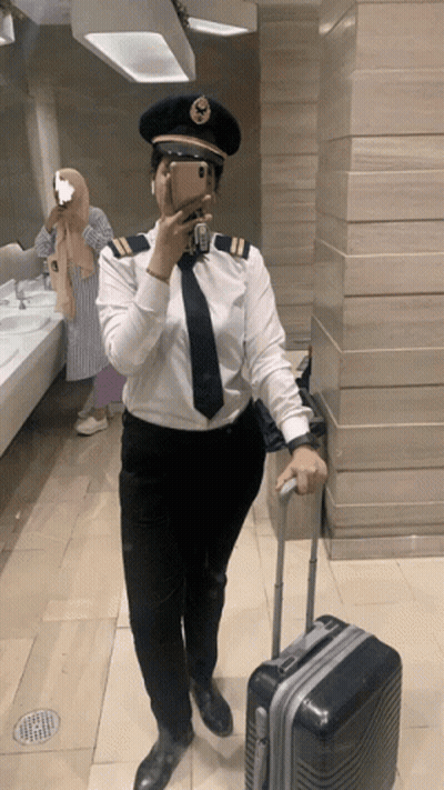 Woman In Pilot Uniform Takes Selfie GIF